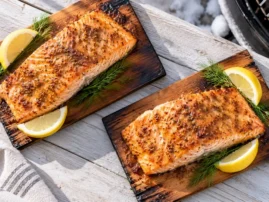 Cedar-plank salmon with brown sugar–Dijon glaze, chopped dill, and lemon wedges.