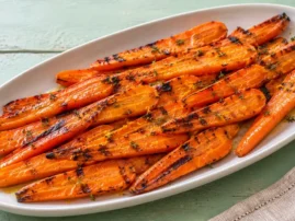 Honey-glazed grilled carrots with orange zest, light grill marks, and fresh thyme.