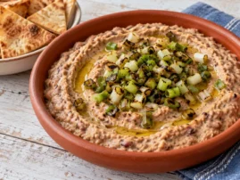 Creamy pink-eyed pea dip topped with charred scallions and served with pita chips.