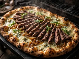 Steak and blue cheese pizza with sliced steak, caramelized onions, and arugula.
